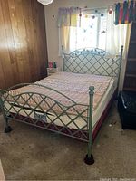 Full view of the metal bed frame assembled with mattress in a room.