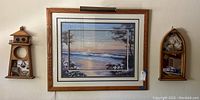 Three piece nautical themed wall art set mounted on a wall showing central beach scene print with wooden frame and two wooden nautical shelves on either side.