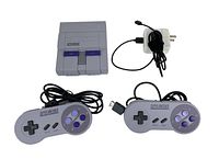 Super Nintendo Entertainment System console with two controllers and a white power adapter with coiled cable.