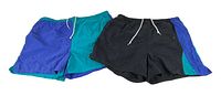 Two pairs of vintage 1990s Cheetah swim trunks, one black with blue and teal panels and white drawstring, and one teal and blue pair with white drawstring.