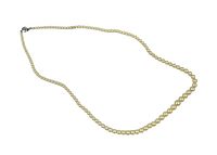 Full view of the vintage pearl necklace showing the entire length and discoloration.