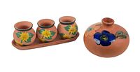Three small hand-painted clay pots on an elongated tray and one round floral clay vase.
