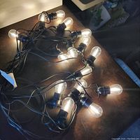 LED string lights illuminated and coiled on a table surface.