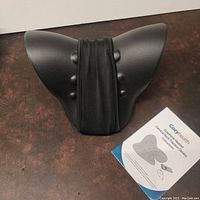 Front view of the cervical neck traction device with mesh strap and user manual