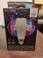 Boxed new BYTECH Double Sided Rotating LED Disco Bulb showing product and packaging, details on patterns, motifs, and multicolor lighting.