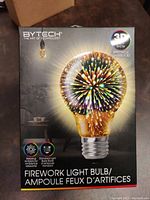 Photo of the product packaging showing the brand 'Bytech' and indicates a 3D spectacle light show bulb producing a relaxing ambient effect with standard E26 screw base.