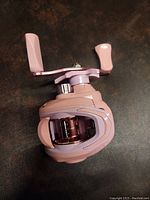 Top view of the pink baitcasting fishing reel showing the handle and spool area