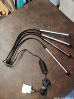 Full view of the grow lamp with 4 flexible LED light bars and attached clamp mount, showing the power adapter and power cord.
