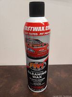 Front view of aerosol can labeled FW1 Wash & Wax High Performance Cleaning Wax with red and black design and red racing car image.