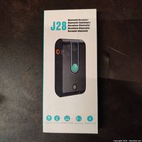 Box packaging showing product image and product name J28 Bluetooth Receiver with multi-language labeling and features icons including hands-free, AUX port, multi-device pairing.