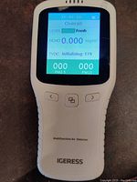 Front view of white IGERESS multifunction air detector showing LCD screen with air quality data and control buttons.