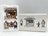 Front view of City News Stand and three accompanying figures in original white foam packaging with box beside it.