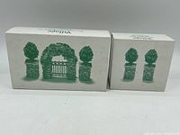 Three-piece Christmas Heritage Village decorative set in original boxes, showing a large greenery gate arch and two smaller pillars.