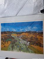 Full view of framed print showing the artwork composition of abstract landscape with blue sky and earthy colors.