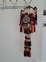 Side view of the full saddle bag showing tassels and circular shell centerpiece