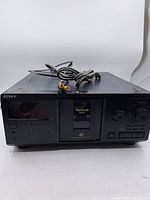 Front view of Sony MegaStorage 300CD multi-disc CD player with power cord on top, black casing and central disc carousel door.