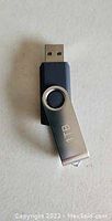 Front view of USB memory stick showing metal swivel cover with 1TB label