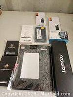 Overview of Apple iPhone cases and charging accessories on a table, showing various boxed and wrapped items.