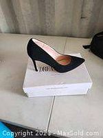 Side view of one black pointed-toe heel on a white Dream Pairs box.