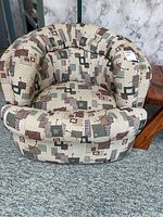 Front view of the tub-style armchair showing the patterned upholstery and overall design.