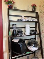 Overview of six small kitchen appliances on dark wood shelf, shows arrangement and items from seller's lot