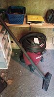Full view of Shop Vac wet/dry vacuum with hose, pipe attachment, floor head on floor.