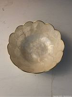Top-down view of the bowl showing scalloped edges and pearlescent seashell texture with gold trim.
