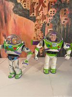 Two Buzz Lightyear action figures side by side showing size difference and detail.