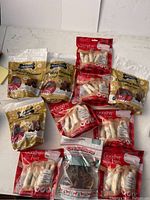 View showing multiple bags of dog treats and rawhide chews from brands Good 'n' Fun, DreamBone, and Three Dog Bakery in assorted packaging.