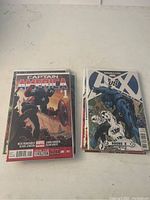 Photo of two Marvel comic books including Captain America #1 and an X-Men issue, both bagged and boarded