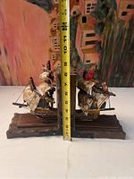 Front and side view of the two wooden pirate ship bookends with measuring tape indicating height around 10 inches