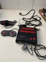 Full console with two wired controllers, power adapter, and AV cables on a white surface.