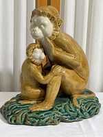 Full view of ceramic monkey figurine showing mother and baby monkeys sitting on textured base.