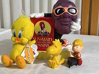 Photo including Sun-Maid Raisin character figurine, Tweety Bird plush, Woodstock and Schroeder Peanuts figures