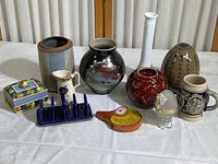 Full view of collection showing vases, ceramic stein, glass egg, blue toast rack, and lidded box.