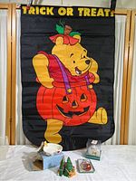 Photo of large nylon outdoor Halloween banner showing Winnie the Pooh holding pumpkin with Trick or Treat text