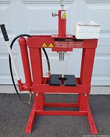 Front view of red MotoMaster 10 ton hydraulic shop press showing frame and base