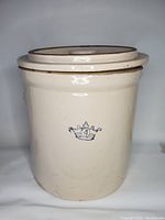 Front view of the cream-colored antique crock with blue crown and number 4 design.