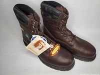 Pair of brown leather men's safety boots showing front and side view with tags attached