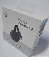 Retail box showing Google Chromecast branding, image of the device, and app icons