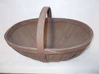 Side profile view of the original Brougham apple basket highlighting the wood strips and handle construction.