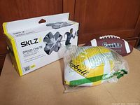 Three items shown: SKLZ Speed Chute box with sprint parachute, uninflated yellow and white volleyball in plastic bag, and brown Franklin football uninflated.