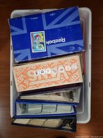 Overhead view of white tub containing two shoe boxes (Reebok, Vans) and three binders holding trading cards