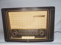 Front view of the vintage Grundig radio showing the Bakelite case, speaker grille, logo, knobs, and preset buttons.