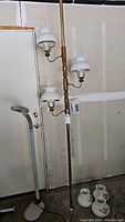Full view of wooden tension floor lamp with three white hobnail glass hurricane lamp shades mounted