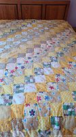 Yellow spring themed patchwork quilt on bed