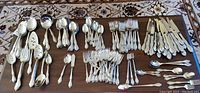 Full overview of entire flatware set arranged on table showing all pieces by type.