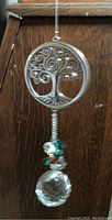 Close-up of metal Tree of Life component with hanging prism bead and faceted crystal prism at bottom.