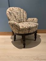 Front view of the French tub chair showing floral tapestry upholstery, carved wood base, and legs with castors.