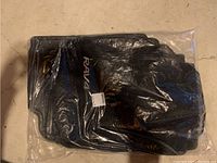 Four black Toyota RAV4 floor mats sealed in original plastic packaging showing unopened condition.